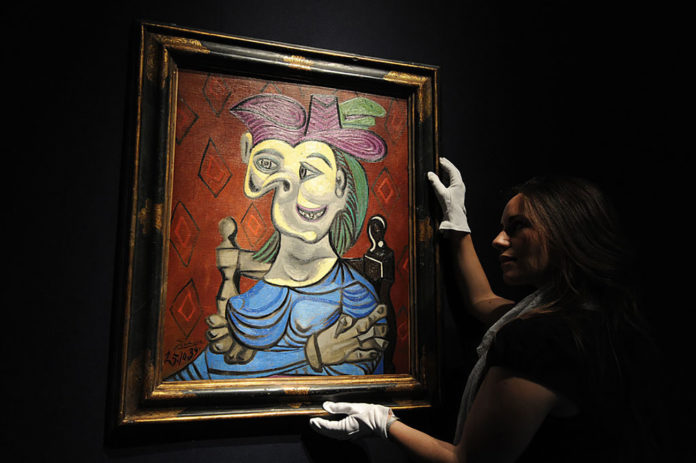 A Christie's employee poses with a paint